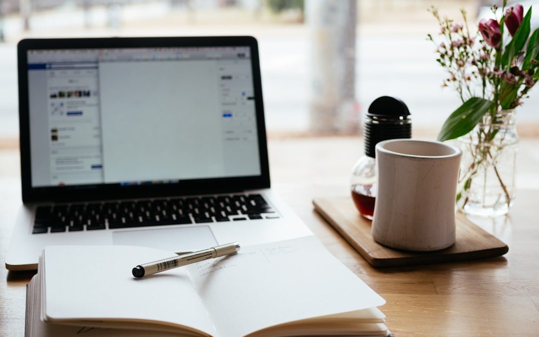 Laptop and notepad used for planning a content strategy